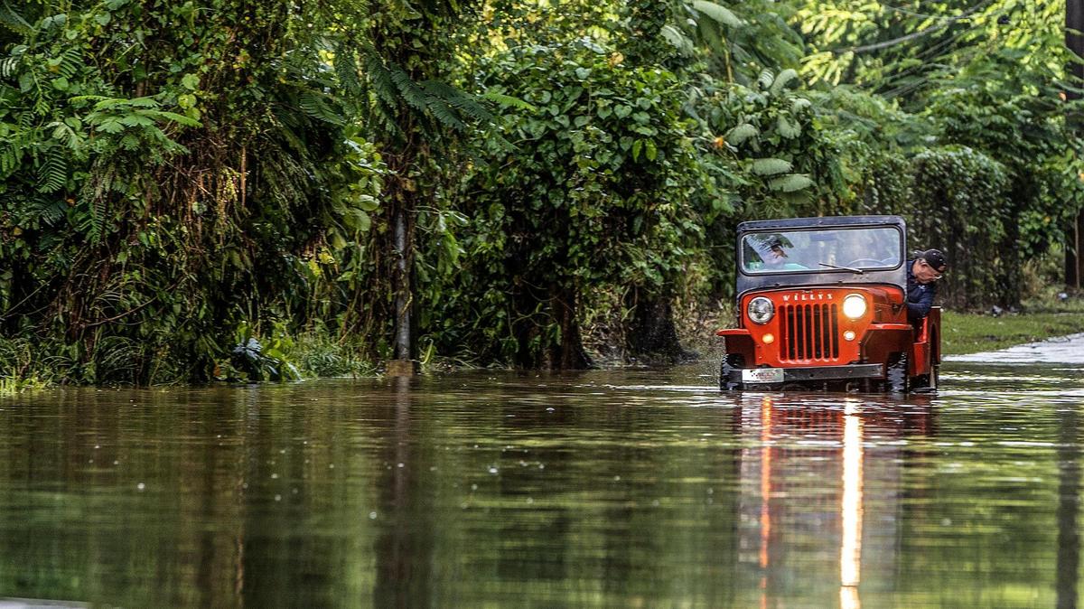 Juan Antonio Molina drives his old jeep through a road flooded in Toa Alta on Tuesday, September 20, 2022. Hurricane Fiona made landfall in Puerto Rico on Sunday, Sept. 18.