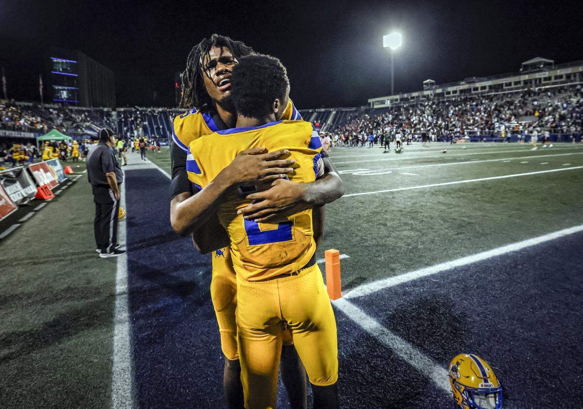 Miami Northwestern Bulls Calvin Russell Jr. (5) and Nicholas Lennear (2) console each other after the Bulls lose to the Raines Vikings during the Class 3A State Championship football game at FIU's Pitbull Stadium in Miami, Florida on Friday, December 12, 2025.