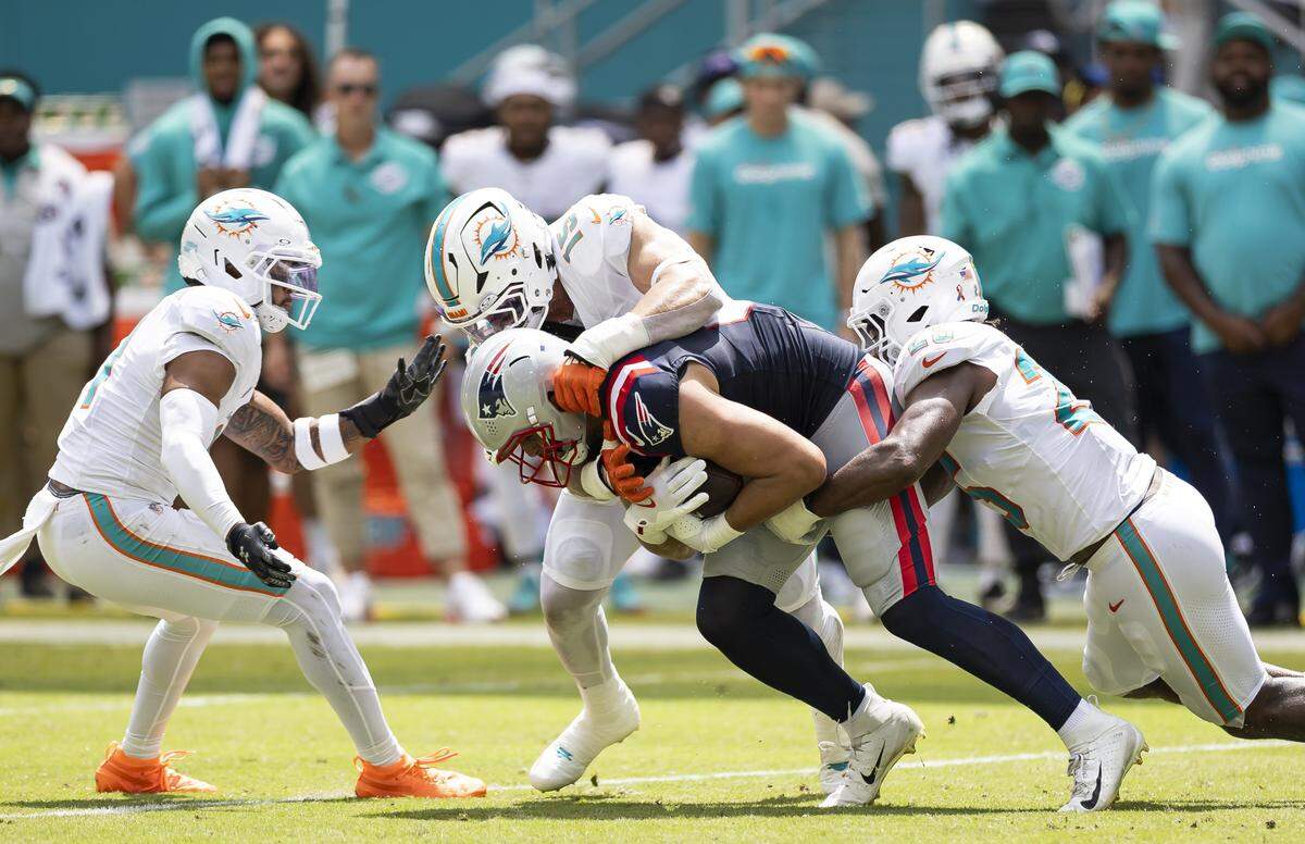 Miami Dolphins linebacker Jaelan Phillips (15) tackles New England Patriots tight end Austin Hooper (81) in the first half of their NFL game.