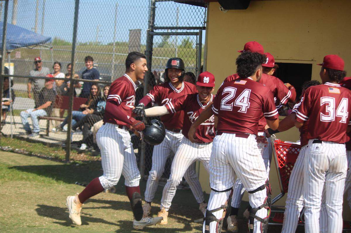 Miami Springs’ Gio Cutino (left) is greeted by his happy teammates following his two-run homer in the first inning of Tuesday’s win over Cardinal Gibbons in a Region 4-4A baseball quarterfinal.