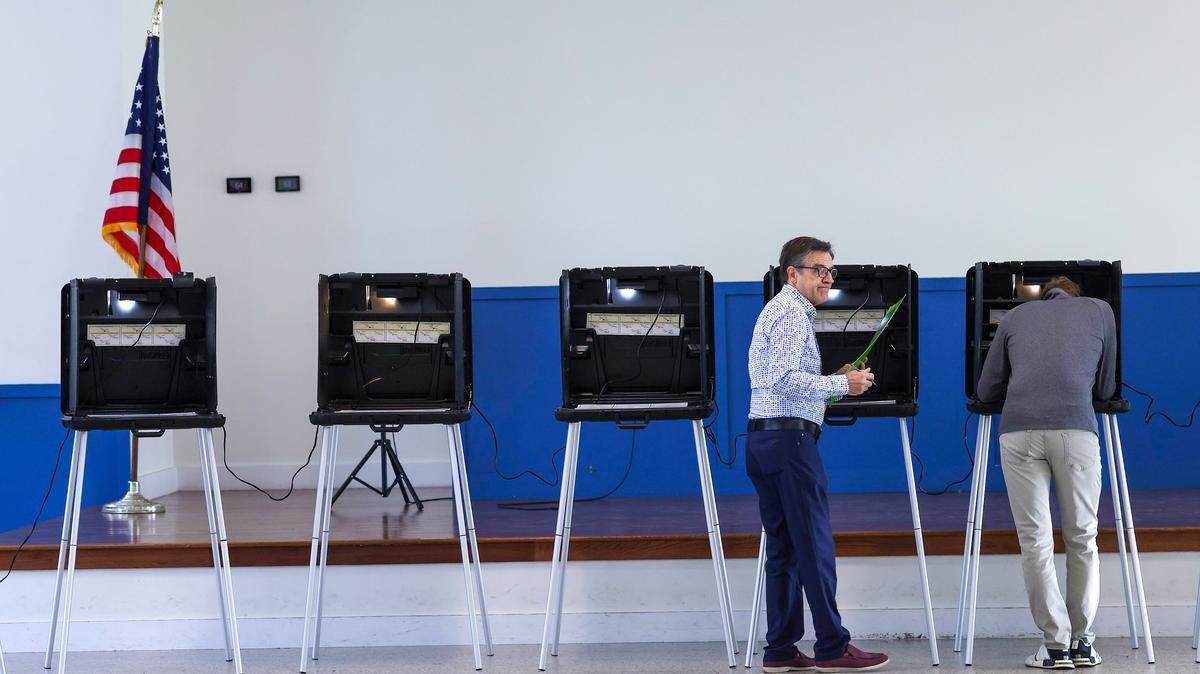 An unidentified Miami resident walks to a ballot box with his ballot in hand after casting his vote as voters head to the polls at Legion Memorial Park Community Center in Miami, Fla., on Tuesday, Nov. 4, 2025.