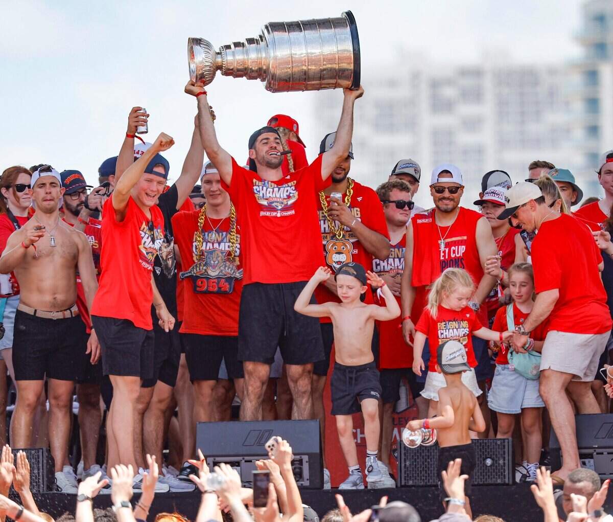Florida Panthers defenseman Jaycob Megna hoists the Stanley Cup as teammates celebrate on stage during the team’s victory parade and rally along A1A in Fort Lauderdale, Florida, on Sunday, June 22, 2025