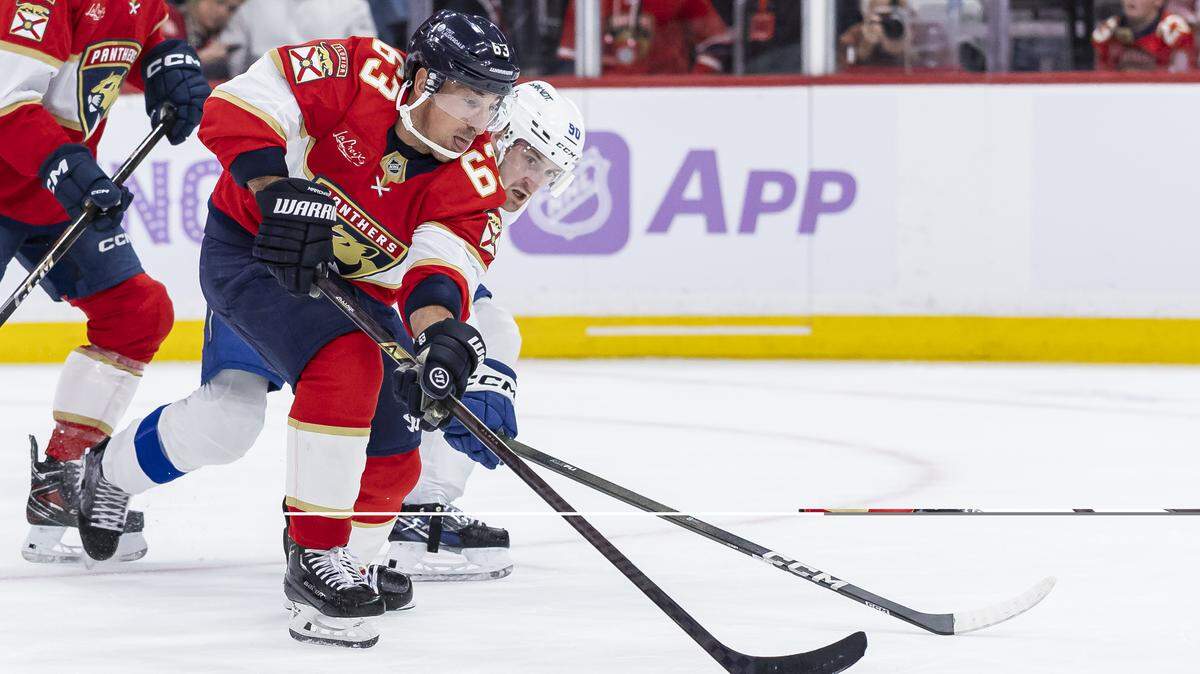 Florida Panthers left wing Brad Marchand (63) looks to shoot the puck as Tampa Bay Lightning defenseman J.J. Moser (90) defends in the second period of their NHL game at the Amerant Bank Arena on Saturday, Nov. 15, 2025, in Sunrise, Fla.
