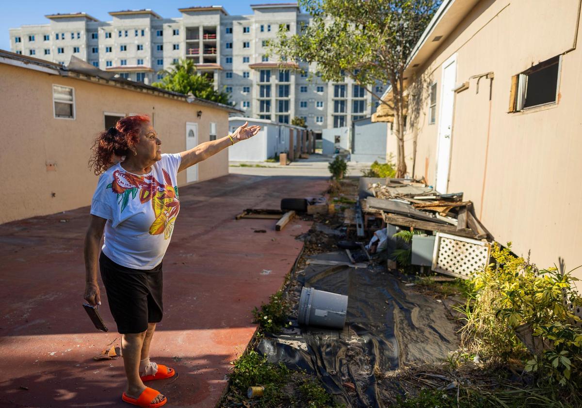 Gladys Arias, residente del parque de casas móviles Li’l Abner, muestra el estado de la casa abandonada de su vecino el viernes 7 de marzo de 2025, en Sweetwater, Florida.