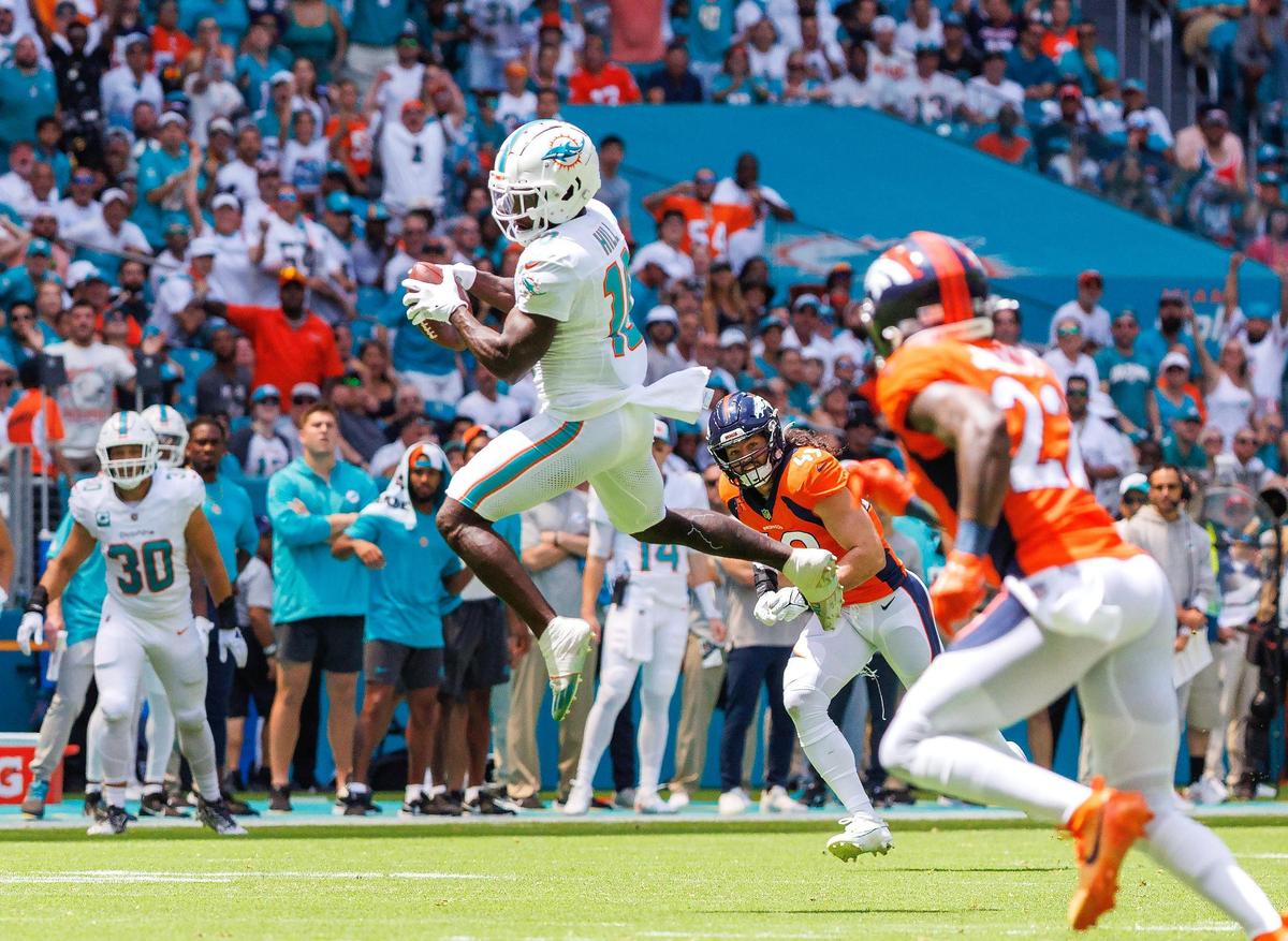 Miami Dolphins wide receiver Tyreek Hill (10) catches a pass as Denver Broncos linebacker Alex Singleton (49) and Broncos safety Kareem Jackson (22) defend during first quarter of an NFL football game at Hard Rock Stadium on Sunday, Sept. 24, 2023 in Miami Gardens, Fl.