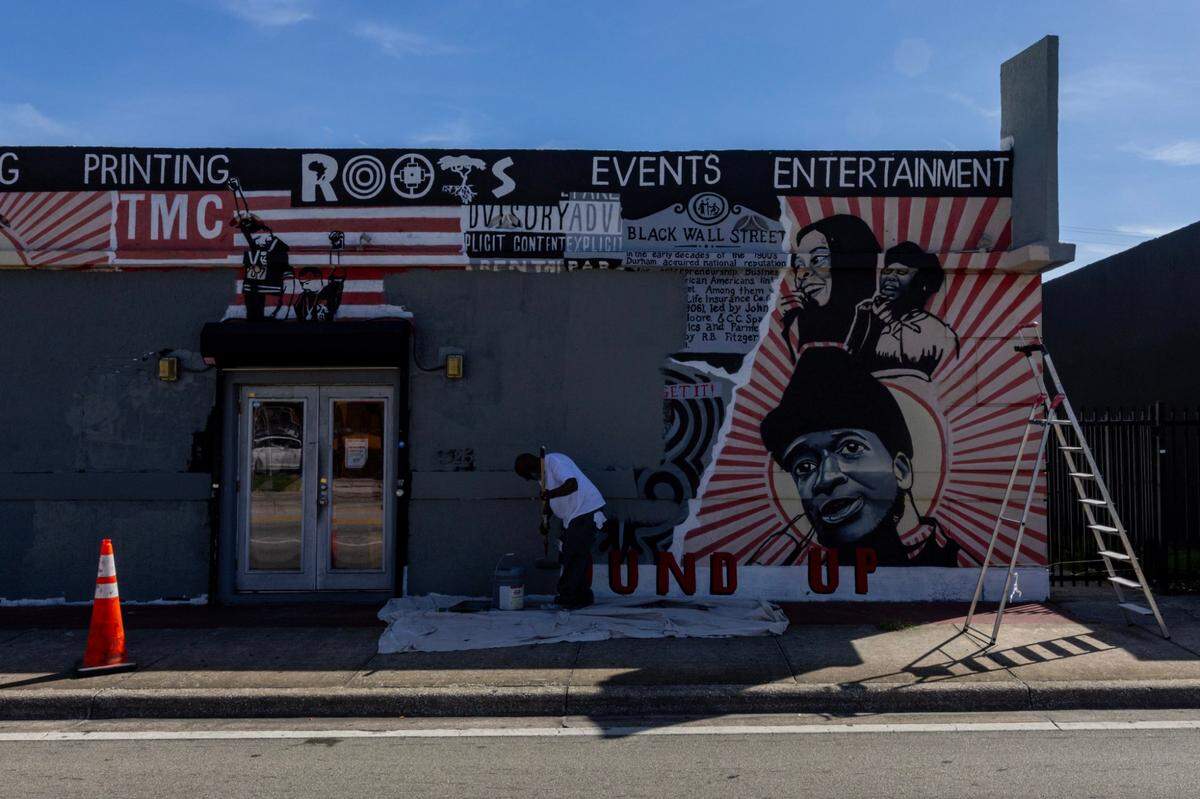 Painter Kendrick Fuller paints over a mural outside of Roots Collective as the organization plans to change locations in Liberty City, Florida, on Friday October 13, 2023.