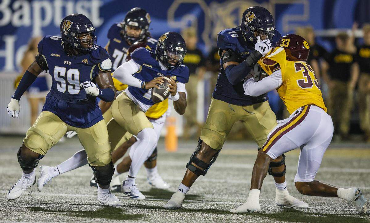 Florida International University Panthers quarterback Keyone Jenkins (1) scrambles as offensive lineman Jaheim Buchanon (59) and offensive lineman Jaleel Davis (78) block against Bethune Cookman defenders at FIU's Pitbull Stadium in Miami, Florida, on Friday, August 29, 2025.