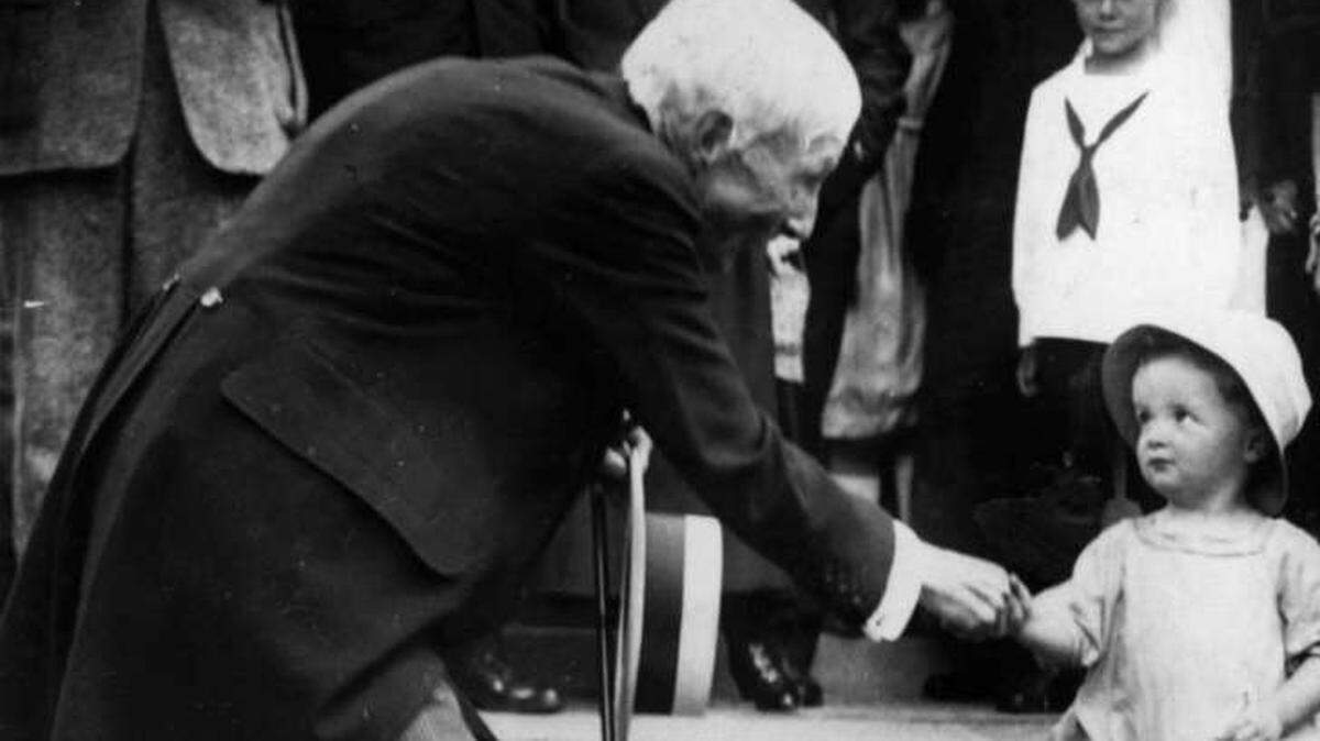 John D. Rockefeller, made incredibly wealthy during the Industrial Revolution, hands as coin to a child.
