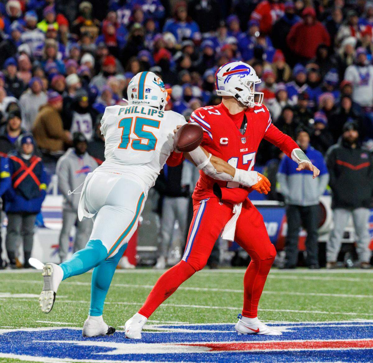 Miami Dolphins linebacker Jaelan Phillips (15) strip-sack Buffalo Bills quarterback Josh Allen (17) during fourth quarter of an NFL football game at Highmark Stadium on Saturday, December 17, 2022 in Orchard Park, New York.