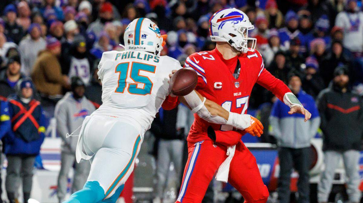 Miami Dolphins linebacker Jaelan Phillips (15) strip-sack Buffalo Bills quarterback Josh Allen (17) during fourth quarter of an NFL football game at Highmark Stadium on Saturday, December 17, 2022 in Orchard Park, New York.