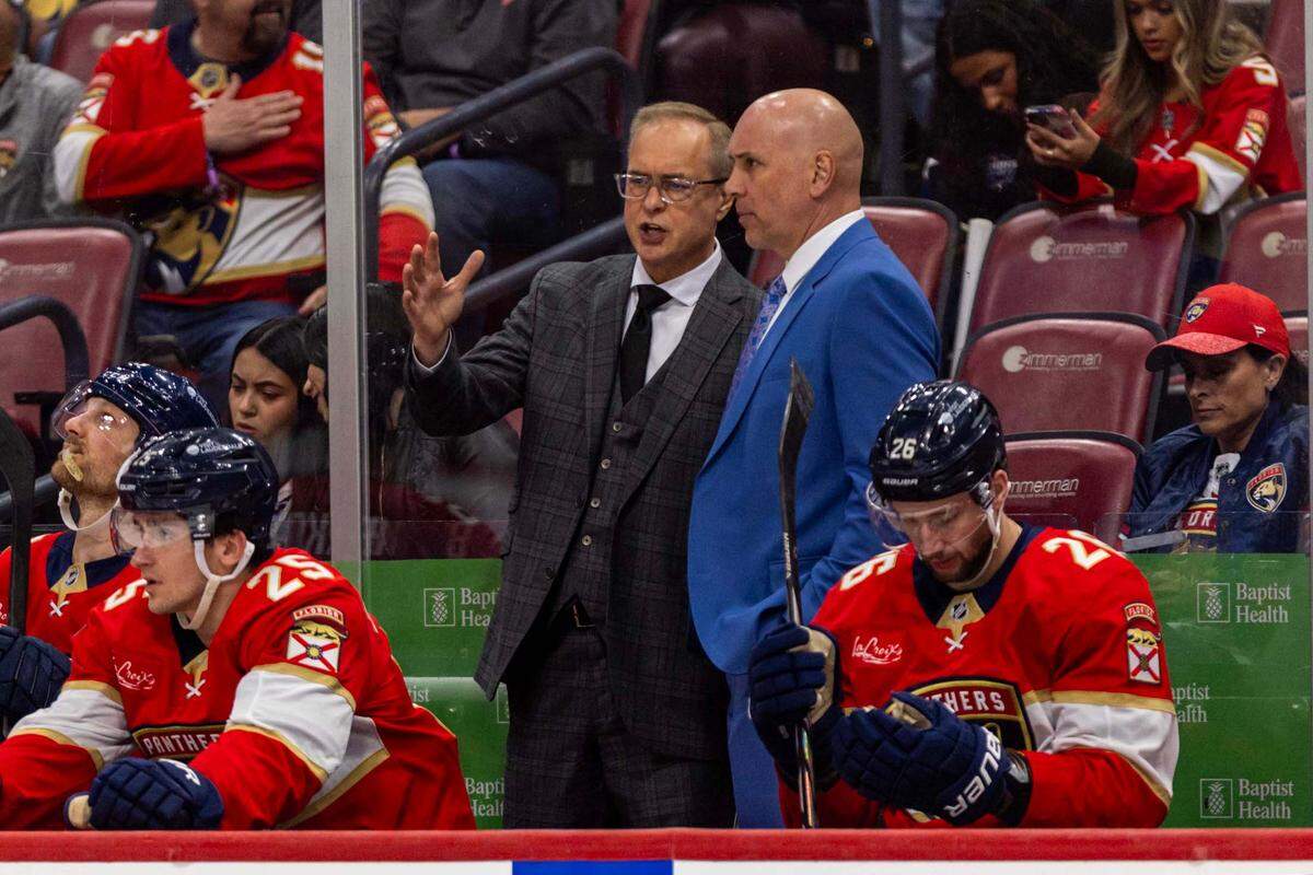 Florida Panthers Head Coach Paul Maurice and Assistant Coach Sylvain Lefebvre speak inside the Panthers bench during the third period of an NHL game against the Detroit Red Wings at Amerant Bank Arena on Thursday, April 10, 2025, in Sunrise, Fla.