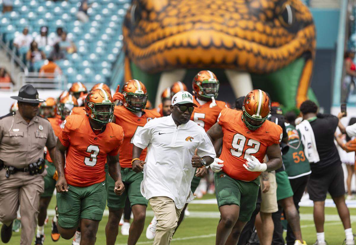 Florida A&M Rattlers head coach James Colzie III runs on the field with his players before playing against Howard Bison in their Orange Blossom Classic football game at Hard Rock Stadium on Saturday, Aug. 30, 2025, in Miami Gardens, Fla.