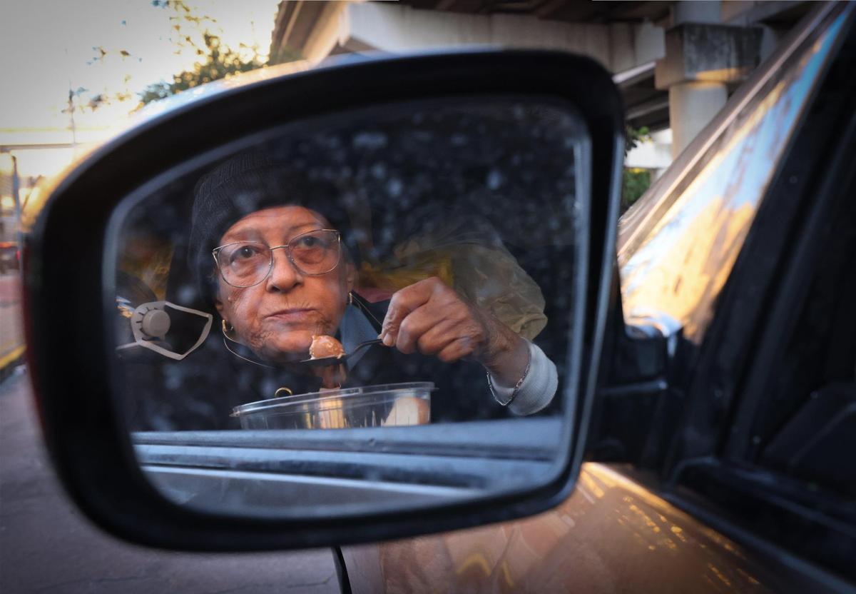 75-year-old Maria Morales eats a meal provided by One World One Heart in her car, which doubles as her home, on Thursday, Jan. 9, 2025, in Miami.