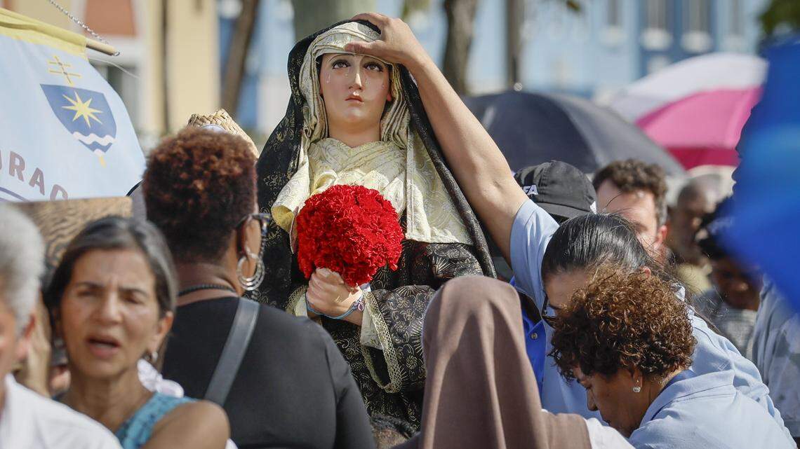 Parishioners adjust the black veil on a statue of Mary during a solemn Stations of the Cross procession along Northwest Second Avenue on Friday, April 3, 2026, in Miami.