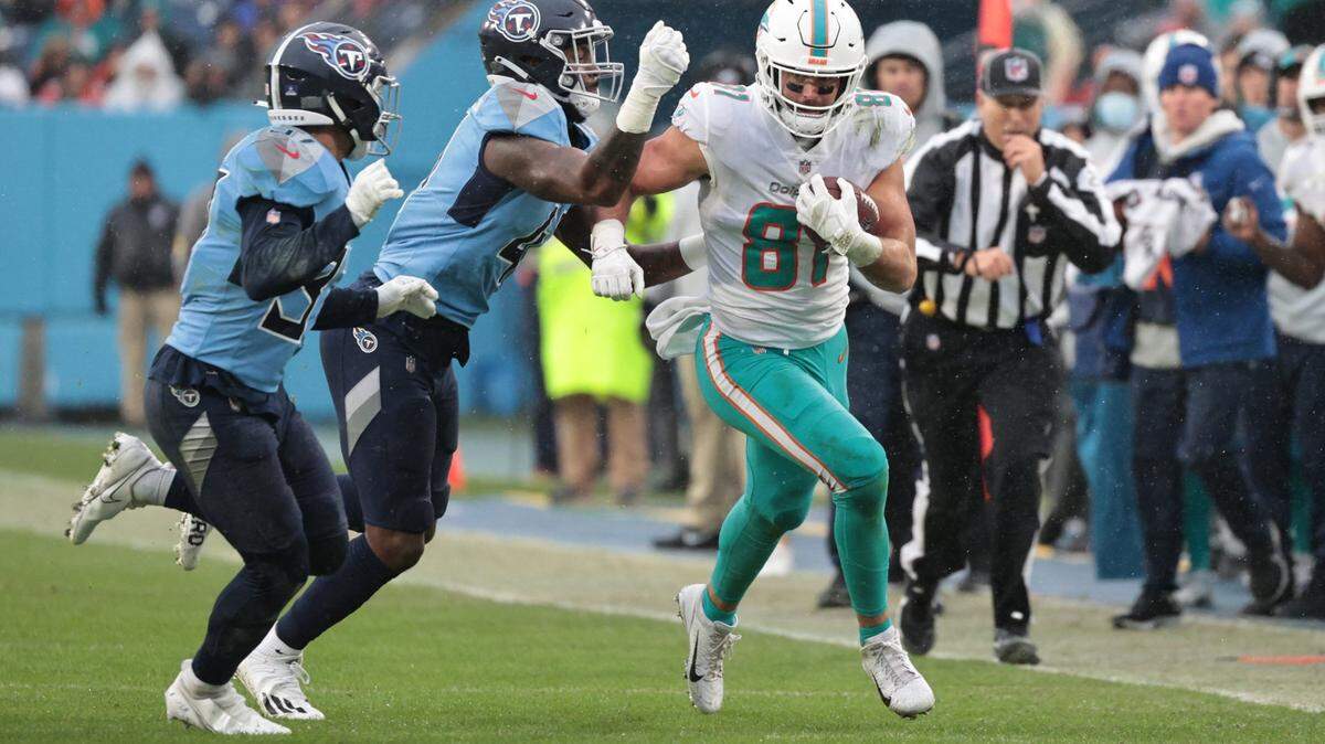 Tennessee Titans outside linebacker Zach Cunningham (41) attempts to punch the ball out of the hands of Miami Dolphins tight end Durham Smythe (81) after a pass reception in the first half at Nissan Stadium in Nashville, Tennessee on Sunday, January 2, 2022.