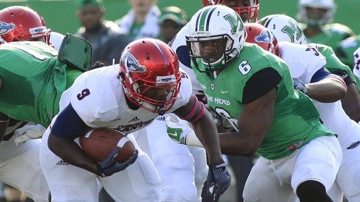 Florida Atlantic's Greg Howell, left, gets by Marshall's Neville Hewitt on Saturday, Oct. 25, 2014 during an NCAA college football game in Huntington, W.Va. Marshall won 35-16.