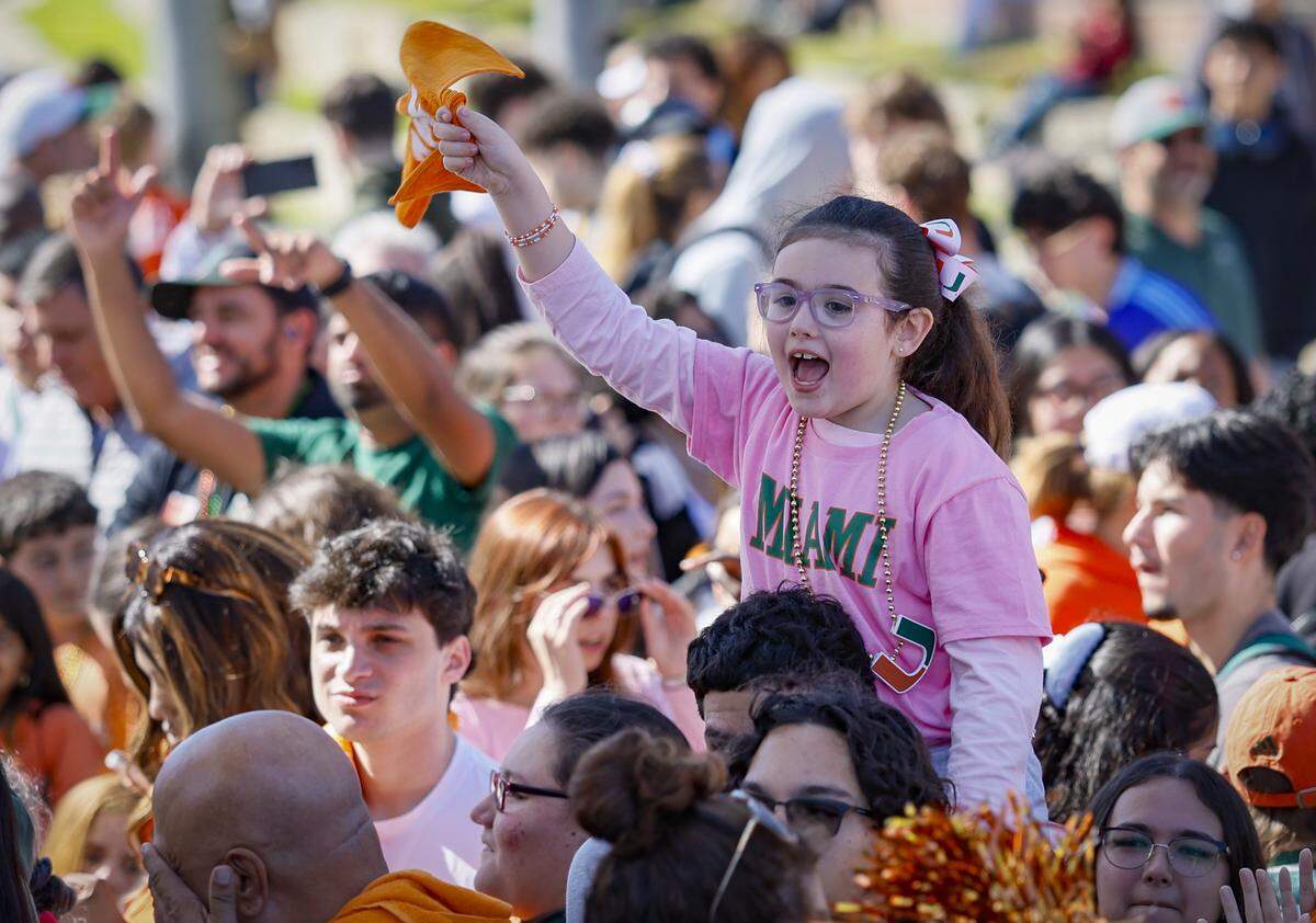 Canes fan Sophie Bernuth, 6, waves a UM souvenir towel during a Miami Hurricanes Pep Rally at the Lakeside Patio at the University of Miami in Coral Gables, Florida, on Friday, January 16, 2026, as they celebrate the upcoming National Championship Game against the Indiana Hoosiers on Monday.  