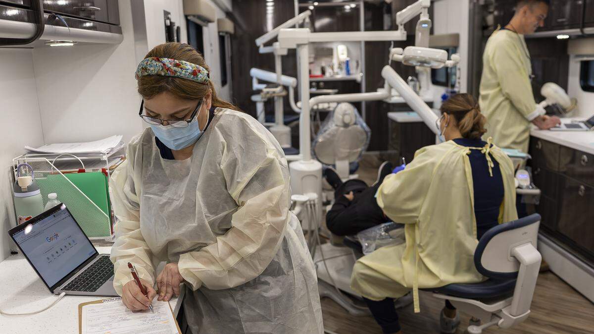 Lily Lopez, a dental assistant with Caring for Miami, fills out paperwork inside the Mobile Dental Clinic in Opa-locka. Caring for Miami is providing free dental care for uninsured and underserved residents.