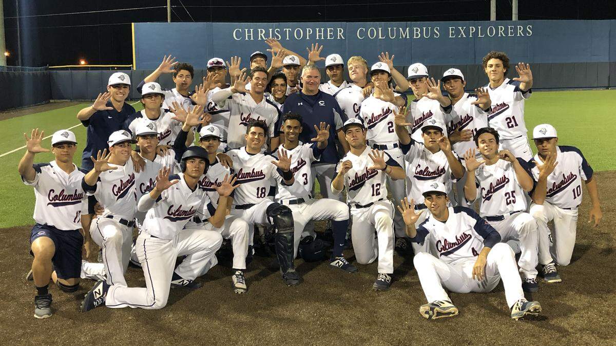 The Columbus Explorers baseball team celebrates with coach Joe Weber on Thursday after Weber earned his 500th career win.