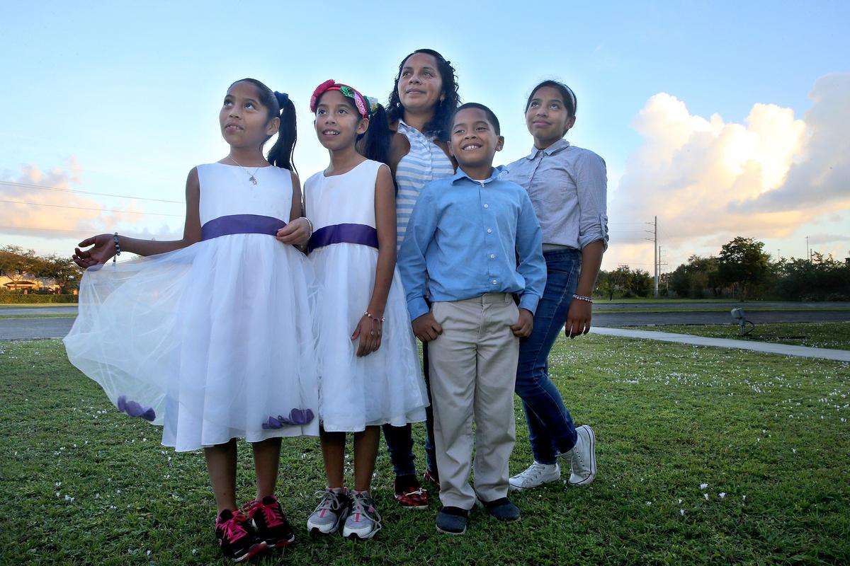 Wendlin Girón, 33, stands with her four children, from left, 10-year-old twins Suamy Yulieth, 8-year-old Uziel and Suamy Lizbeth and 12-year-old Roxana Banegas on Friday, December 12, 2019 outside of the North Dade Community Church. After abandoning their home in Honduras and migrating to the U.S., the family is now staying at the Miami Rescue Mission shelter.