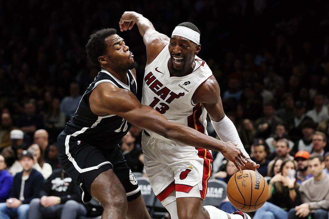 Bam Adebayo #13 of the Miami Heat dribbles against Day'Ron Sharpe #20 of the Brooklyn Nets during the second half at Barclays Center on December 18, 2025 in the Brooklyn borough of New York City.