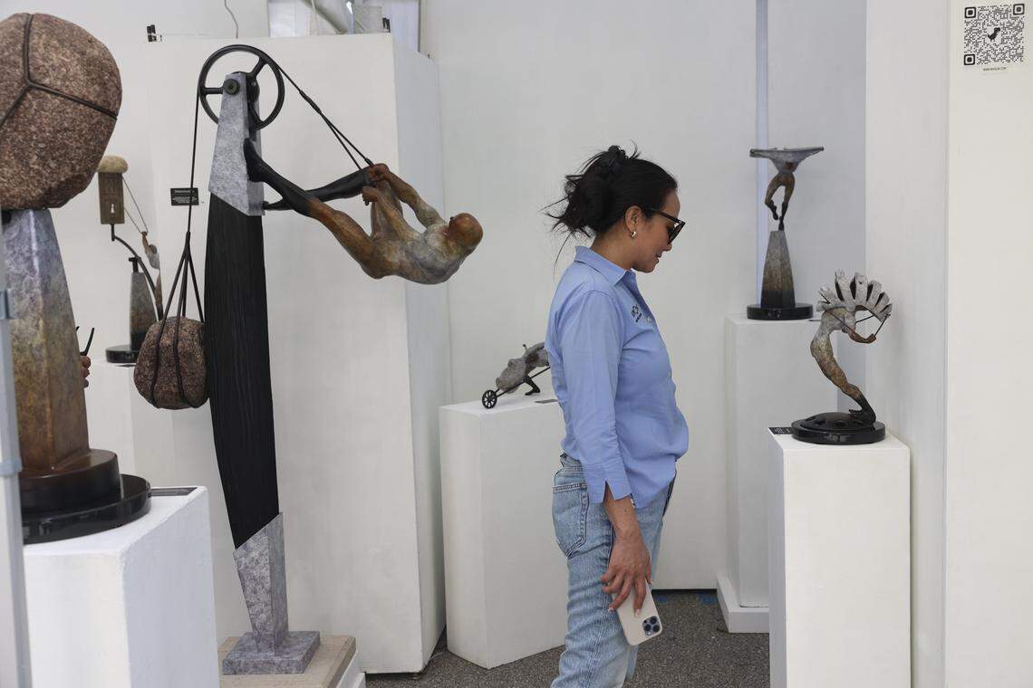 A festival goer looks at sculptures by Thomas Wargin, from Wisconsin, during the 59th annual Coconut Grove Art Festival on Sunday, Feb. 19, 2023, on South Bayshore Drive.