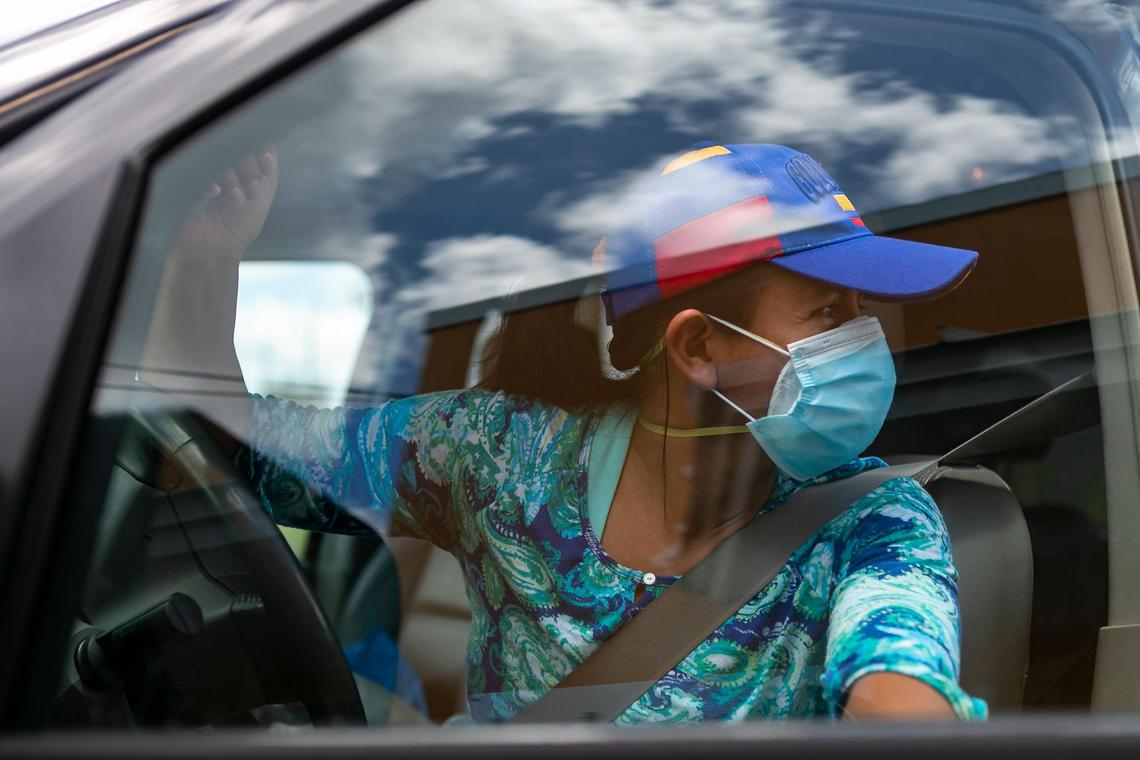 Adriana Hernandez, 43, gets into her vehicle after receiving a free meal from Homestead Soup Kitchen in Homestead, Florida on Friday, June 26, 2020.
