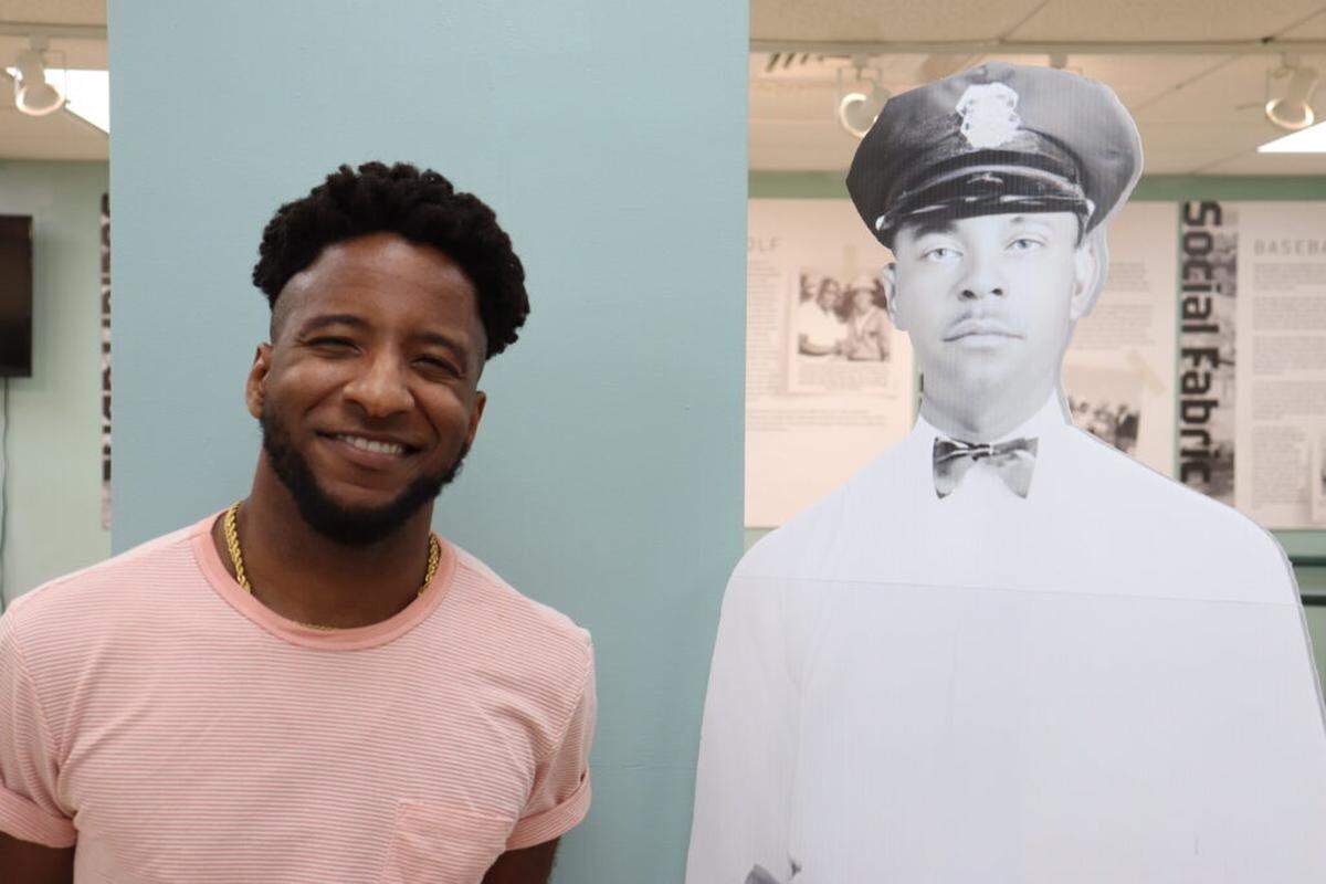 Shown next to a museum cutout of a former police officer at the the Black Police Precinct and Courthouse Museum, Miami, is the curator of “Anything but a Slum,” Jordan Rogers.