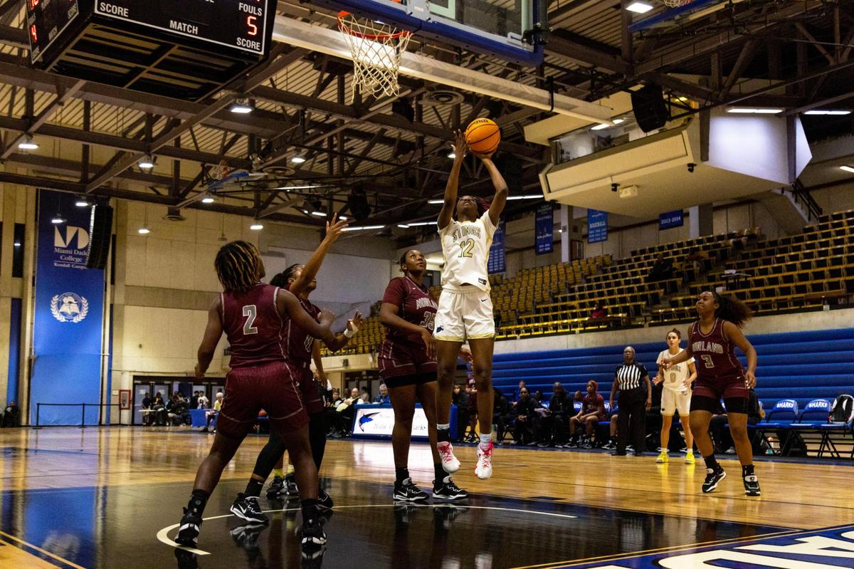 Miami Senior High School center Jamir Cook (12) lays up the ball after driving past Miami Norland Senior High School center Fenishka Bertho (35) during the first half of the women’s GMAC Basketball Finals at Miami-Dade College Kendall campus Gibson Gymnasium in Miami, Florida, on Friday, January 27, 2023.