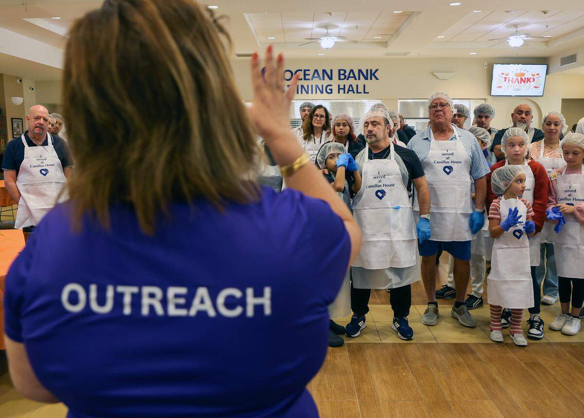 Volunteers gather for final instruction are given as Camillus House opens its dinning area to 500 clients for a Thanksgiving meal.  Camillus House held its 65th annual Thanksgiving Celebration, a cherished tradition that brings hope, dignity, and fellowship to hundreds of individuals experiencing shelter insecurity with a Thanksgiving dinner and other activities at its main campus on Thursday, November 27, 2025, in Miami, Florida. 