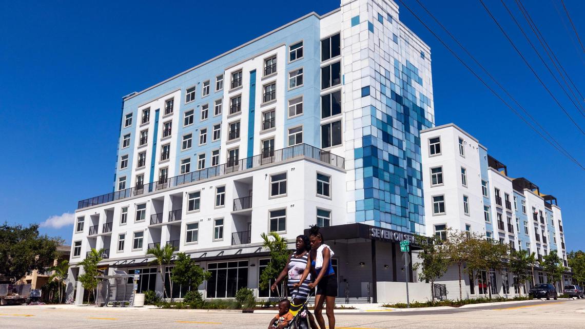 Two women and a baby cross the street in front of the new $25 million Seven on Seventh apartment building in Fort Lauderdale on Sept. 13, 2023. The apartments are for tenants who need stable homes and local workers.