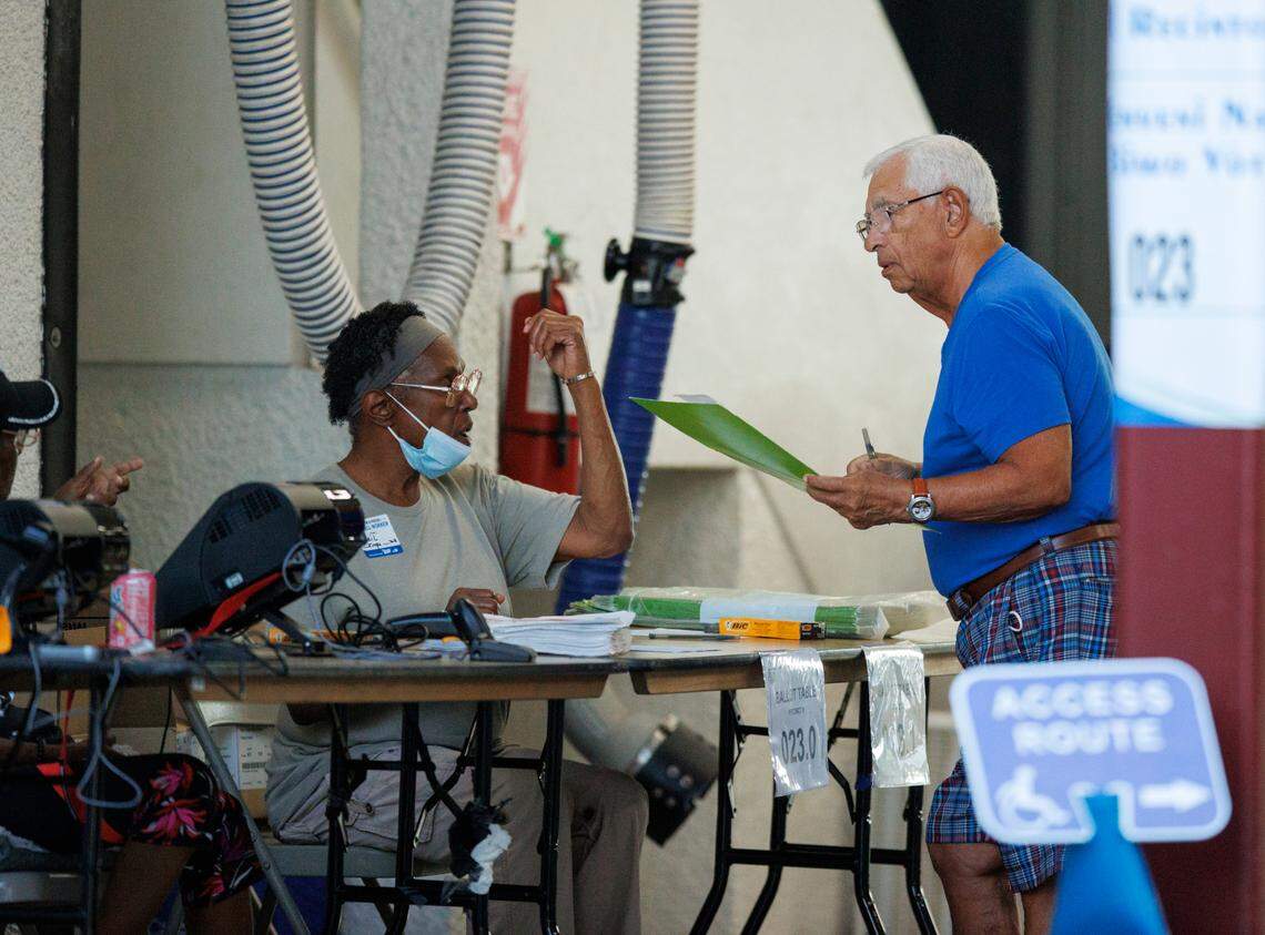 Poll workers assist a voter as votes cast during the Florida primary election at the Miami Beach Fire Department - Station 3 on Tuesday, Aug. 23, 2022, in Miami Beach, Florida.
