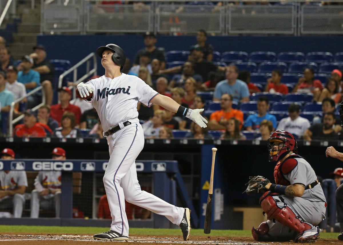 Miami Marlins first baseman Garrett Cooper (26) hits a grand slam as he follows through the ball during the second inning of an Major League Baseball game against the St. Louis Cardinals at Marlins Park in Miami on Wednesday, June 12, 2019.