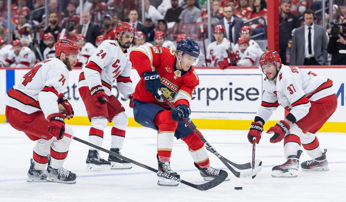 Florida Panthers center Anton Lundell (15) competes for the puck against Carolina Hurricanes defenseman Jaccob Slavin (74) and right wing Andrei Svechnikov (37) in the second period of Game 4 during the Eastern Conference final of the NHL Stanley Cup playoffs at Amerant Bank Arena on Monday, May 26, 2025, in Sunrise, Fla.