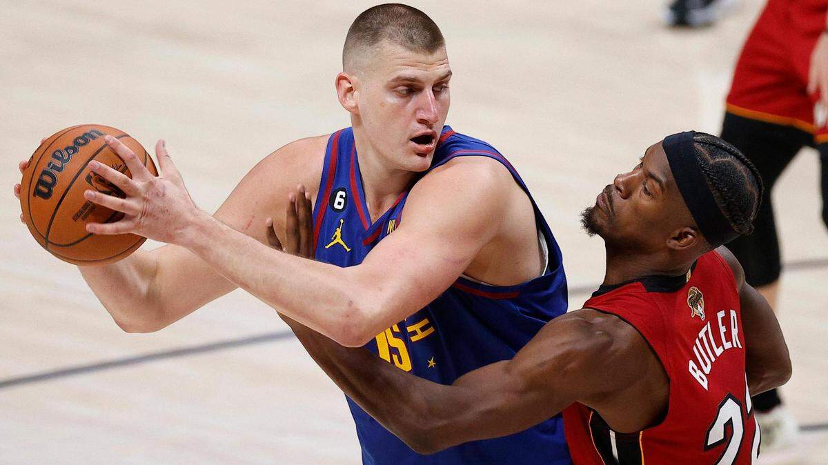 Denver Nuggets center Nikola Jokic (15) controls the ball while defended by Miami Heat forward Jimmy Butler (22) during the second quarter in game one of the 2023 NBA Finals at Ball Arena.