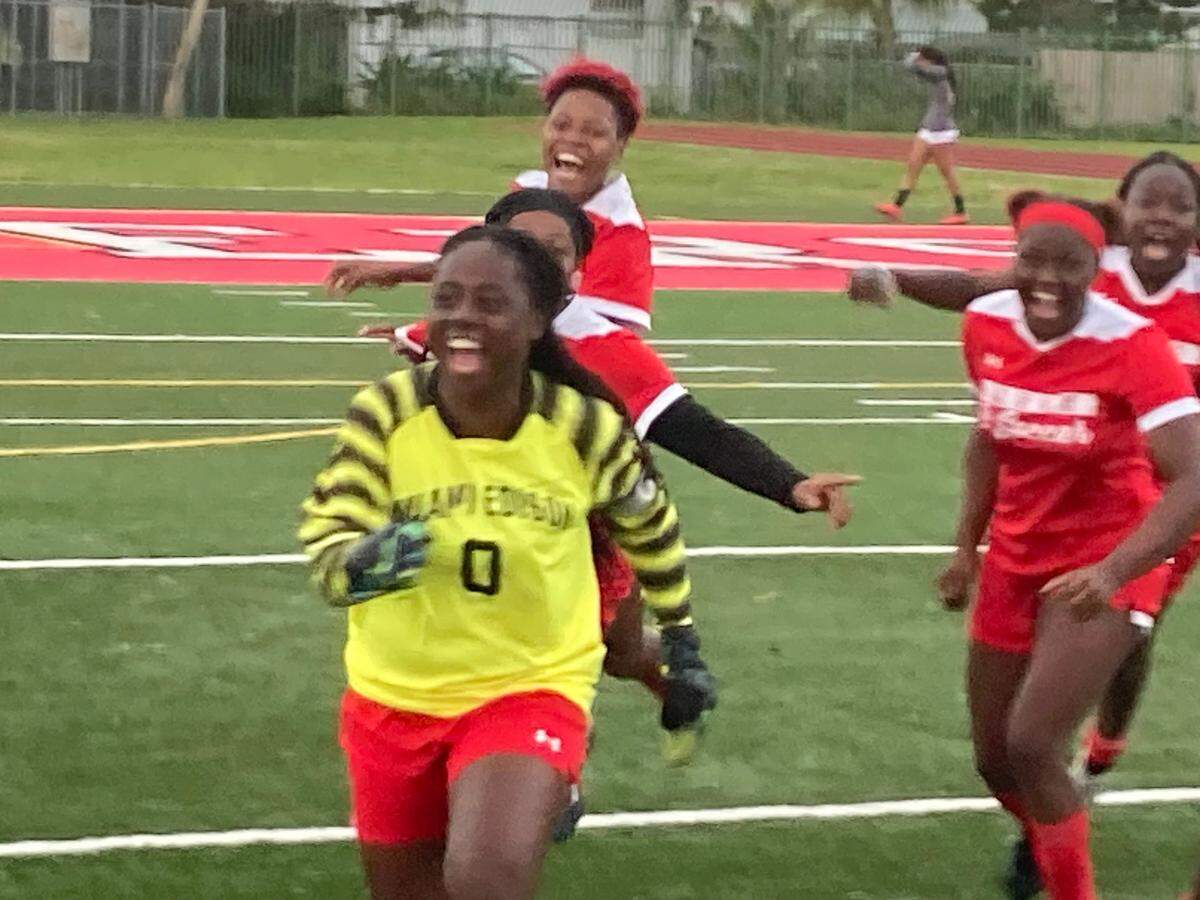 Miami Edison goalkeeper Dadie-Love Cherenfant celebrates with her teammates after making the game-winning save in penalty kicks as the Red Raiders beat Ransom Everglades on Friday at home to advance to the Region 4-3A final.