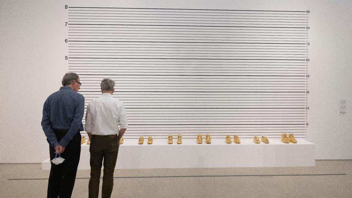 People look at a piece called ‘Lineup’ during a walk through of the Gary Simmons Public Enemy exhibit on Thursday, Jan. 18, 2024, at Perez Art Museum in downtown Miami. According to the description, “the works in this room imply absent bodies, prompting visitors to conjure their own mental images who might populate these settings. By removing these figures from these scenes, Simmons suggests that, as Black bodies are sensationalized and marketed, the individuality of Black subjects is erased and replaced by racial stereotypes.”