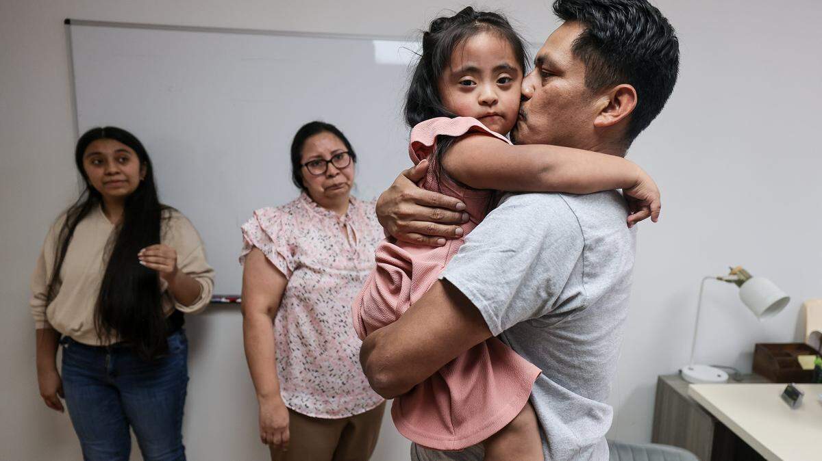 Perla, left, and wife Yolanda, looks at Rogelio, 39, right, a Guatemalan citizen who has lived in the United States since 2007 and is married to a U.S. citizen, as he embraces his daughter Daniela, center, after being released by ICE on Wednesday, February 18, 2026, and arrived at his lawyer's office in Miami, Florida.
