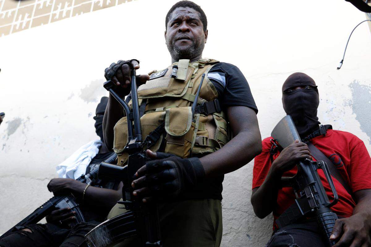 Jimmy Chérizier, a former elite police officer known as Barbecue who became the leader of a powerful gang federation, stands with his fellow gang members after speaking to journalists in the Delmas 6 neighborhood of Port-au-Prince in Port-au-Prince, Haiti, on March 5, 2024. (AP Photo/Odelyn Joseph)