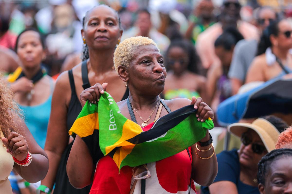 A woman with a Jamaican flag dances during the 19th annual Best of the Best International Music Festival at Bayfront Park in downtown Miami, Sunday, May 25, 2025. This was the concert’s first return after a two-year-hiatus.