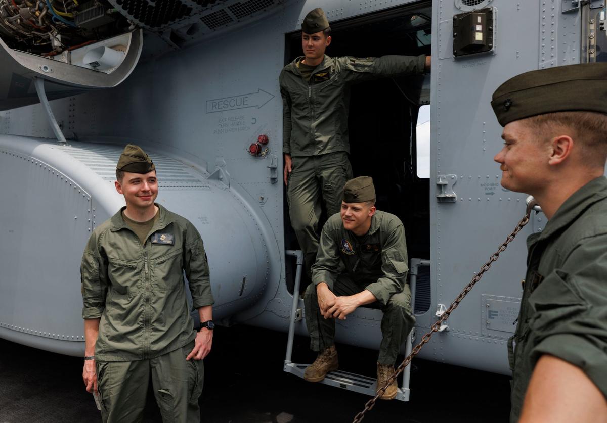 Members of a heavy marine helicopter squadron talk outside the CH-53K super stallion helicopter during the opening day of Fleet Week on Monday, May 6, 2024, at Norwegian Cruise Lines Terminal in PortMiami.