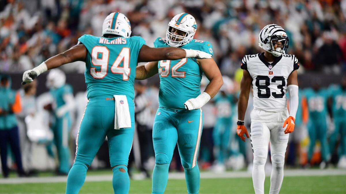 Miami Dolphins defensive tackle Zach Sieler (92) high fives defensive tackle Christian Wilkins (94) during an NFL football game against the Cincinnati Bengals, Thursday, Sept. 29, 2022, in Cincinnati. (AP Photo/Emilee Chinn)
