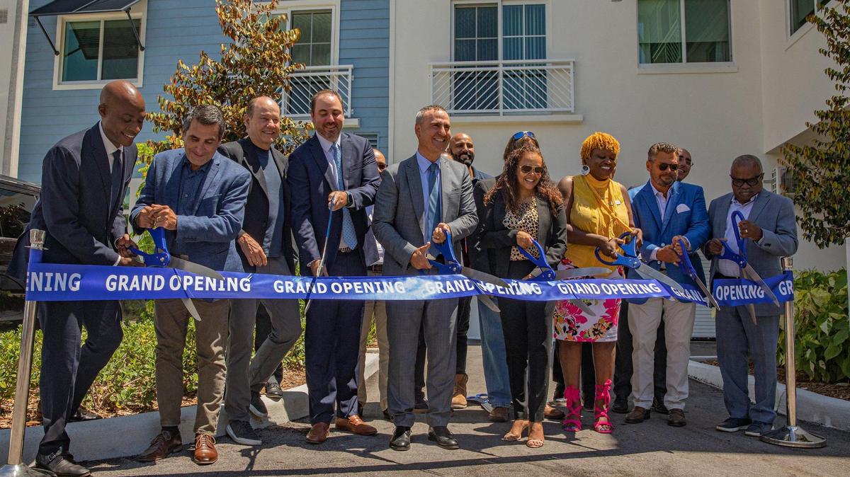 Un grupo de personas corta una cinta para celebrar la gran inauguración de Father Richard Marquess-Barry Apartments el martes 28 de junio de 2022, en Miami. El edificio de apartamentos pretende crear viviendas asequibles dentro del mercado cada vez más caro de Miami.