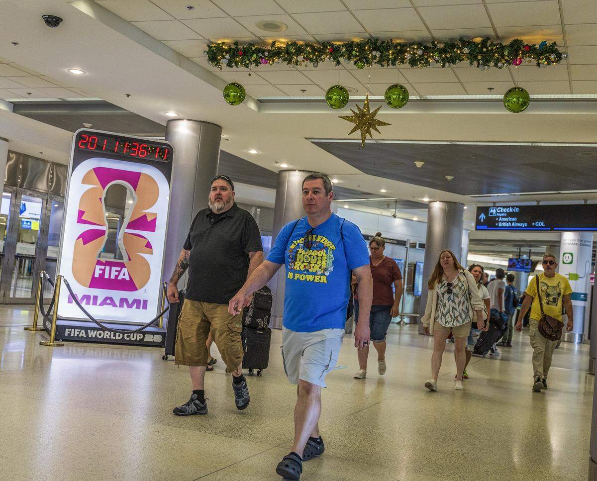 Passengers walked by the FIFA Countdown clock and some holidays decorations Concourse D, at Miami International Airport ahead of the holidays in Miami, on Friday, November 21, 2025.