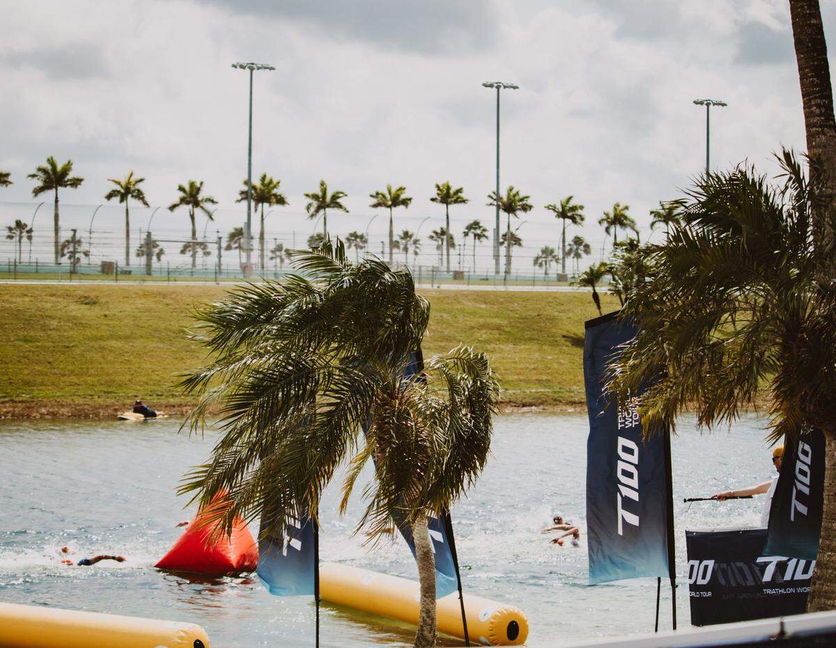 Triathletes swimming in the man-made lake in the center of the Homestead Miami Speedway on Mar. 9, 2024.