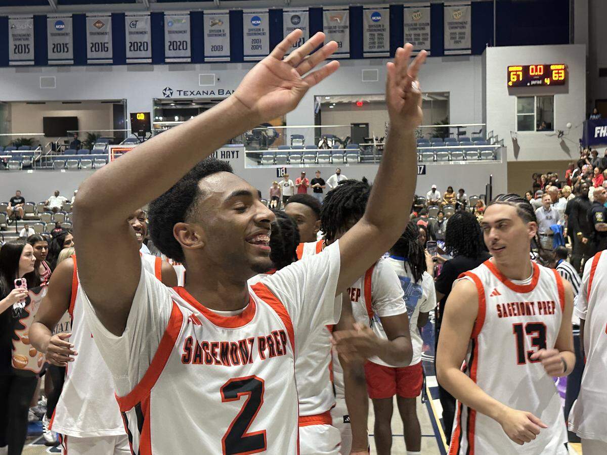 Sagemont’s Ezra Gelin holds up four fingers signifying the Lions’ fourth consecutive state championship, which they won on Saturday at UNF Arena in Jacksonville, Fla.