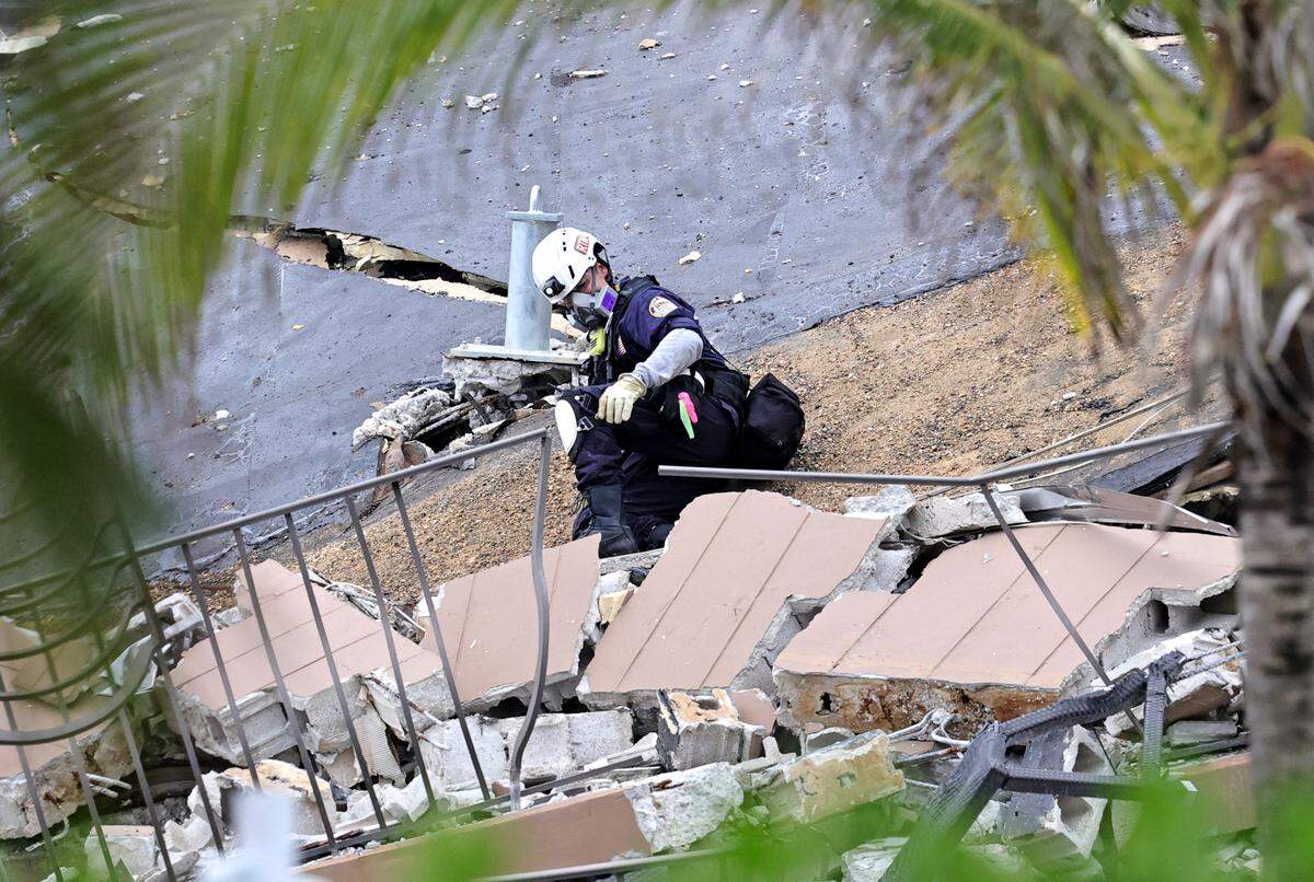 A first responder searches for survivors in rubble at Champlain Towers South in Surfside on Friday, June 25, 2021.