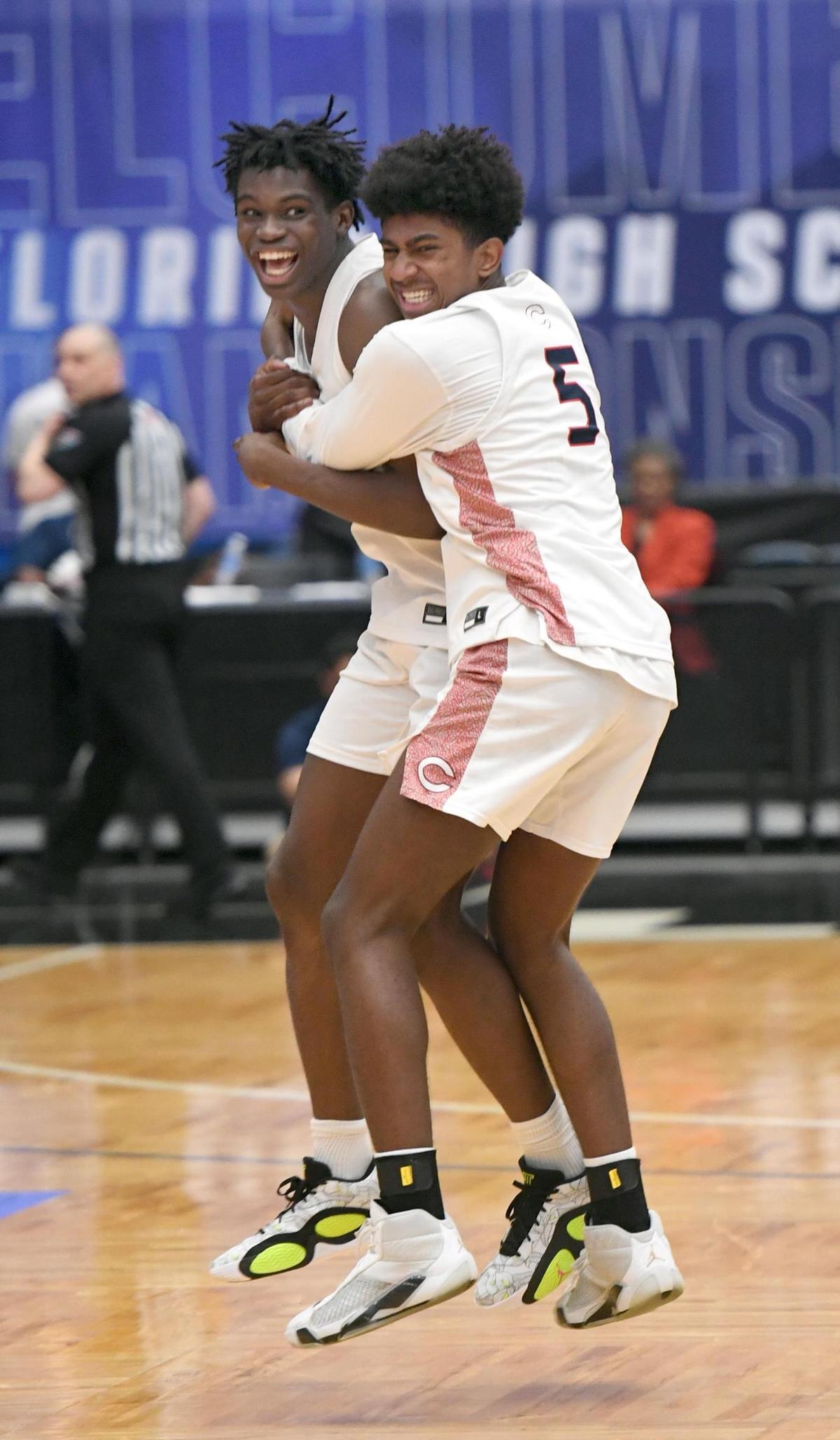 Columbus’ Malik Abdullahi (24) and Jaxon Richardson celebrate after beating Oak Ridge in the Class 7A final during the Florida High School State Championships at the RP Funding Center in Lakeland, Fl on Saturday March 9, 2024. Columbus defeated Oak Ridge 72-67 in overtime. Scott Wheeler | Photo