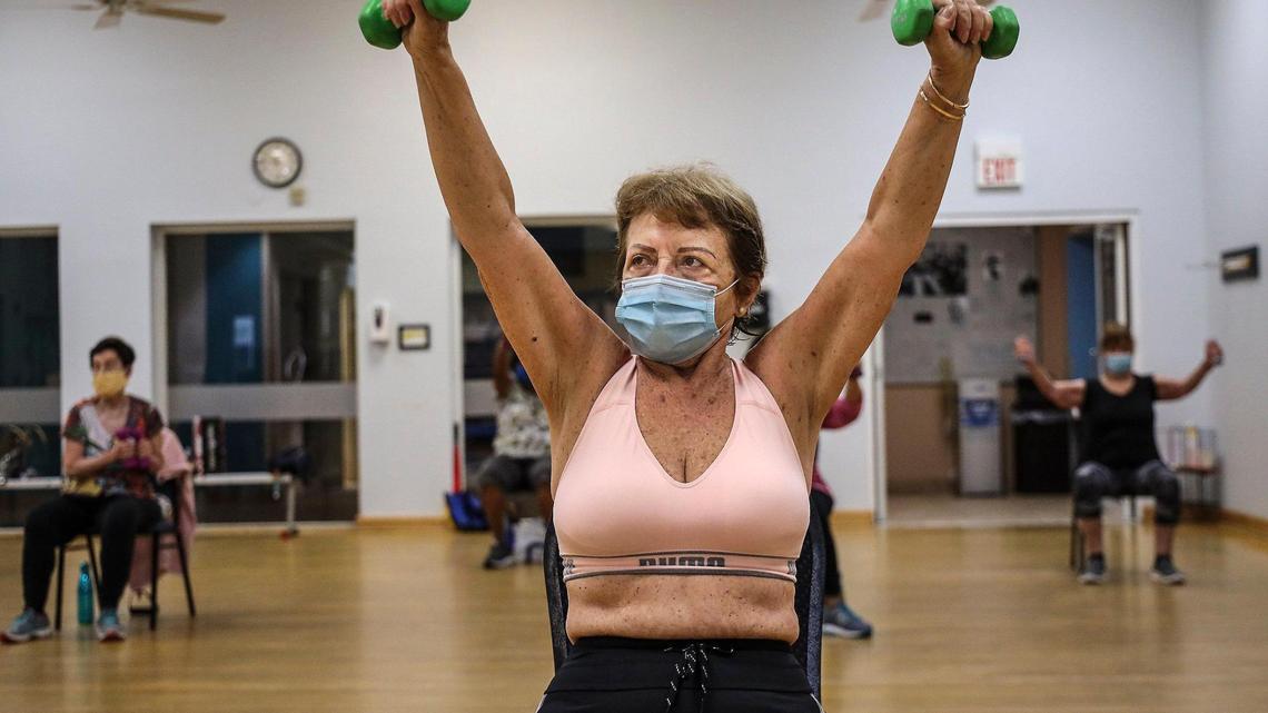 Elma Hamblet Bastien lifts her arms while working with weights during the Medicare Advantage program that offers up Silver Sneakers fitness classes at the Alper Jewish Community Center in Kendall.