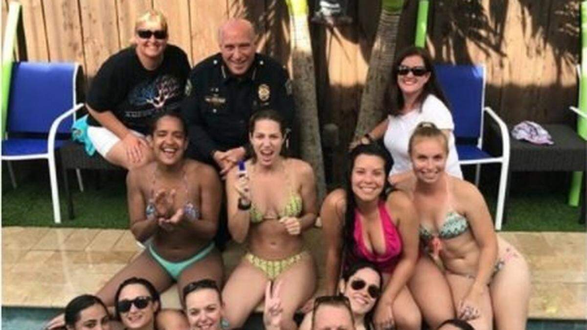 Coral Gables Police Chief Ed Hudak, in uniform,  visited a pool party thrown by fellow officers last July. His picture with bikini-clad female officers sparked an investigation by the city.